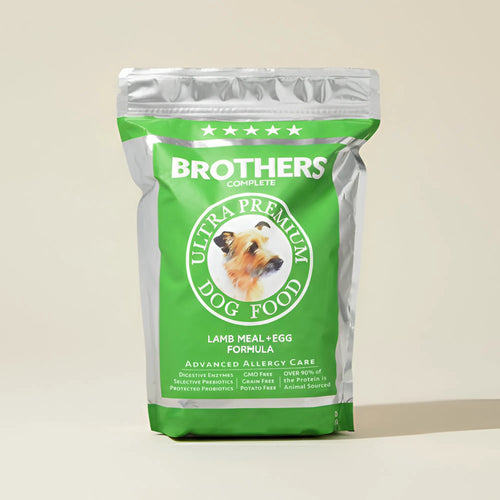Green bag of Brothers Complete Ultra Premium Dog Food on a beige background