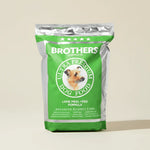 Green bag of Brothers Complete Ultra Premium Dog Food on a beige background